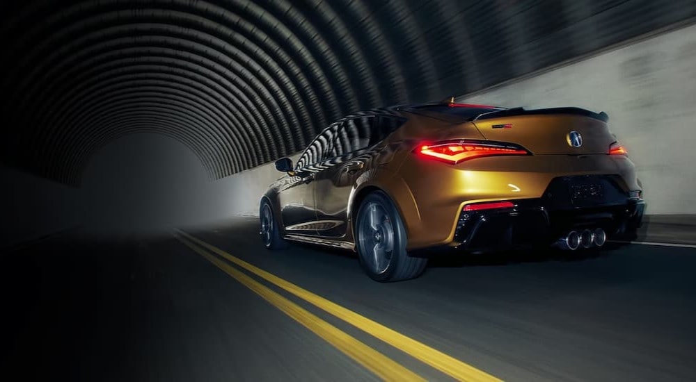 Rear of a yellow 2024 Acura Integra Type S driving through a tunnel.