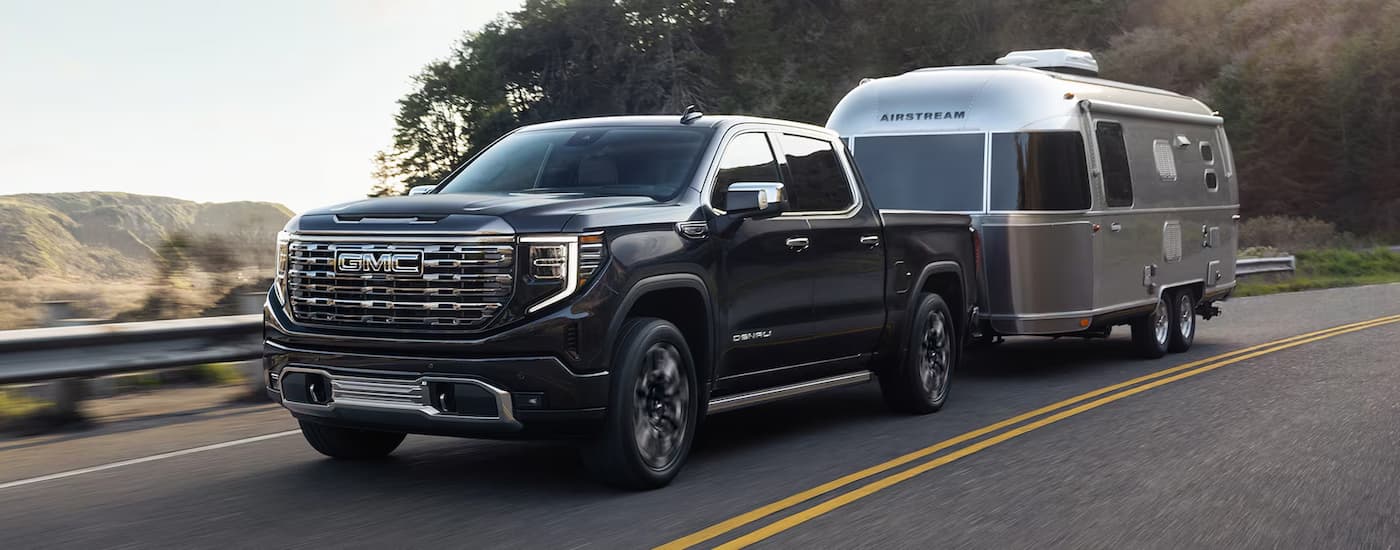 Black 2025 GMC Sierra 1500 Denali towing a silver Airstream trailer