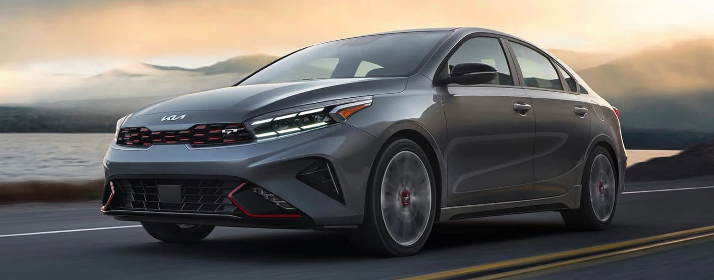 A gray 2023 Kia Forte Gt driving to a car dealer near Chapel Hill.