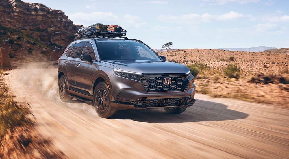 A gray 2025 Honda CR-V Sport Hybrid driving off-road.