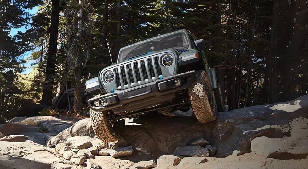A grey 2024 Jeep Wrangler 4xe is shown off-roading.