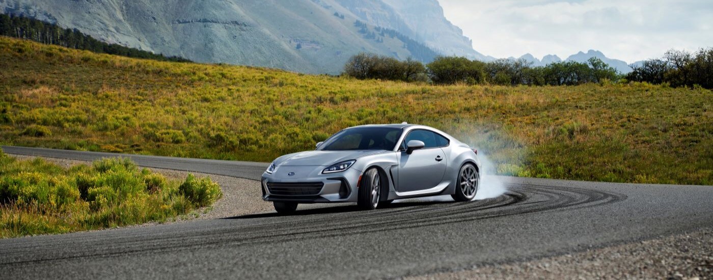 A silver 2022 Subaru BRZ is shown drifting around a corner.