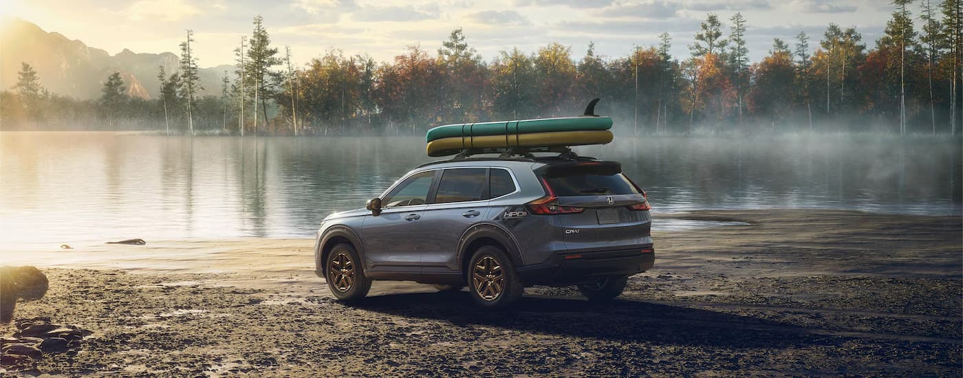 Grey 2025 Honda CR-V Hybrid parked near a lake.