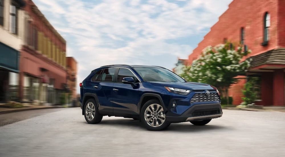 A blue 2025 Toyota RAV4 parked near a car dealer near Roswell.